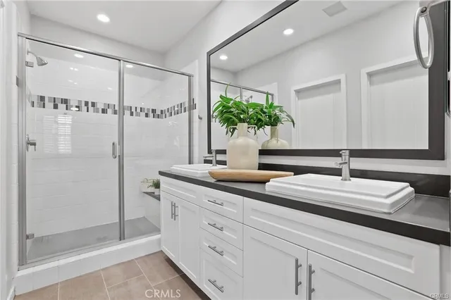 a bathroom with double vanity and a mirror