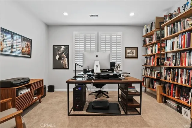 a view of a workspace with furniture and a bookshelf