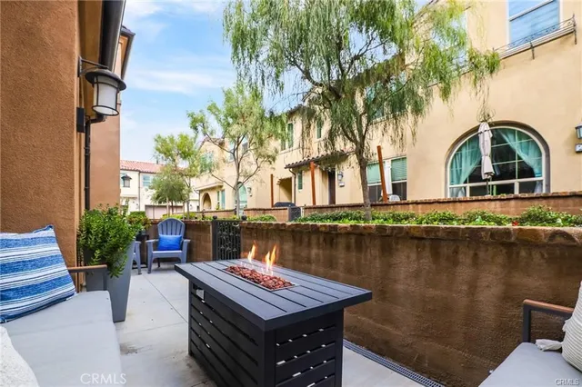 a balcony with table and chairs and potted plants