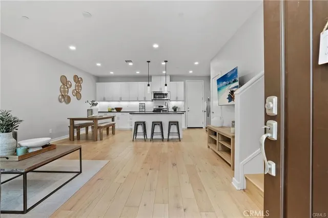 a living room with stainless steel appliances furniture and a kitchen view