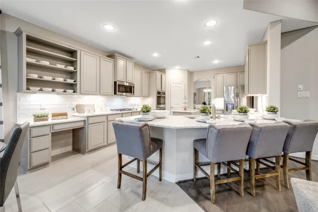 a kitchen with a dining table chairs and sink