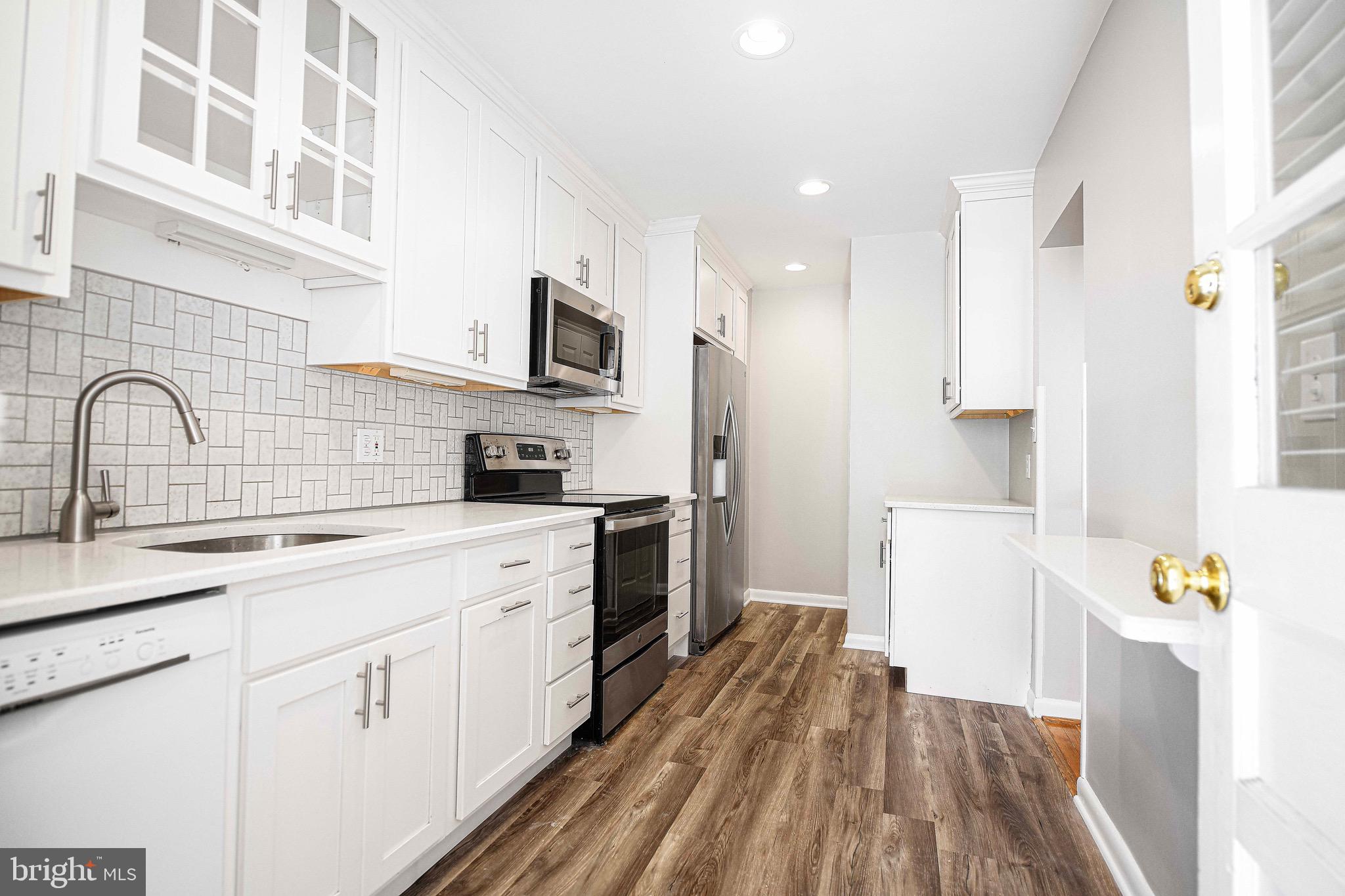 8559 Morven Road Baltimore, MD 21234 - Photo 11 of 27 a kitchen with stainless steel appliances granite countertop a stove a sink dishwasher and a refrigerator with wooden floor