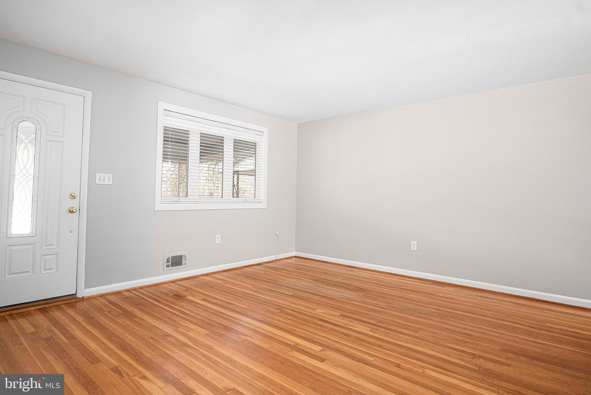 8559 Morven Road Baltimore, MD 21234 - Photo 4 of 27 an empty room with wooden floor and windows