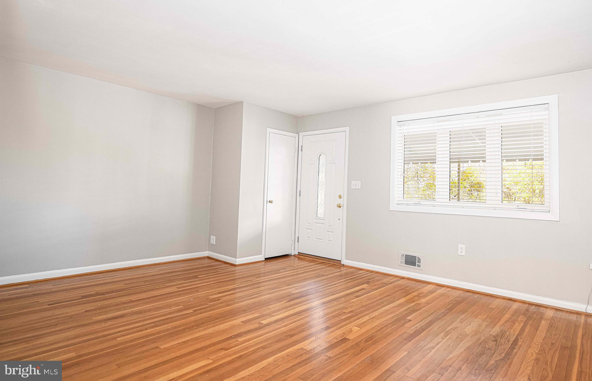 8559 Morven Road Baltimore, MD 21234 - Photo 7 of 27 a view of an empty room with wooden floor and a window