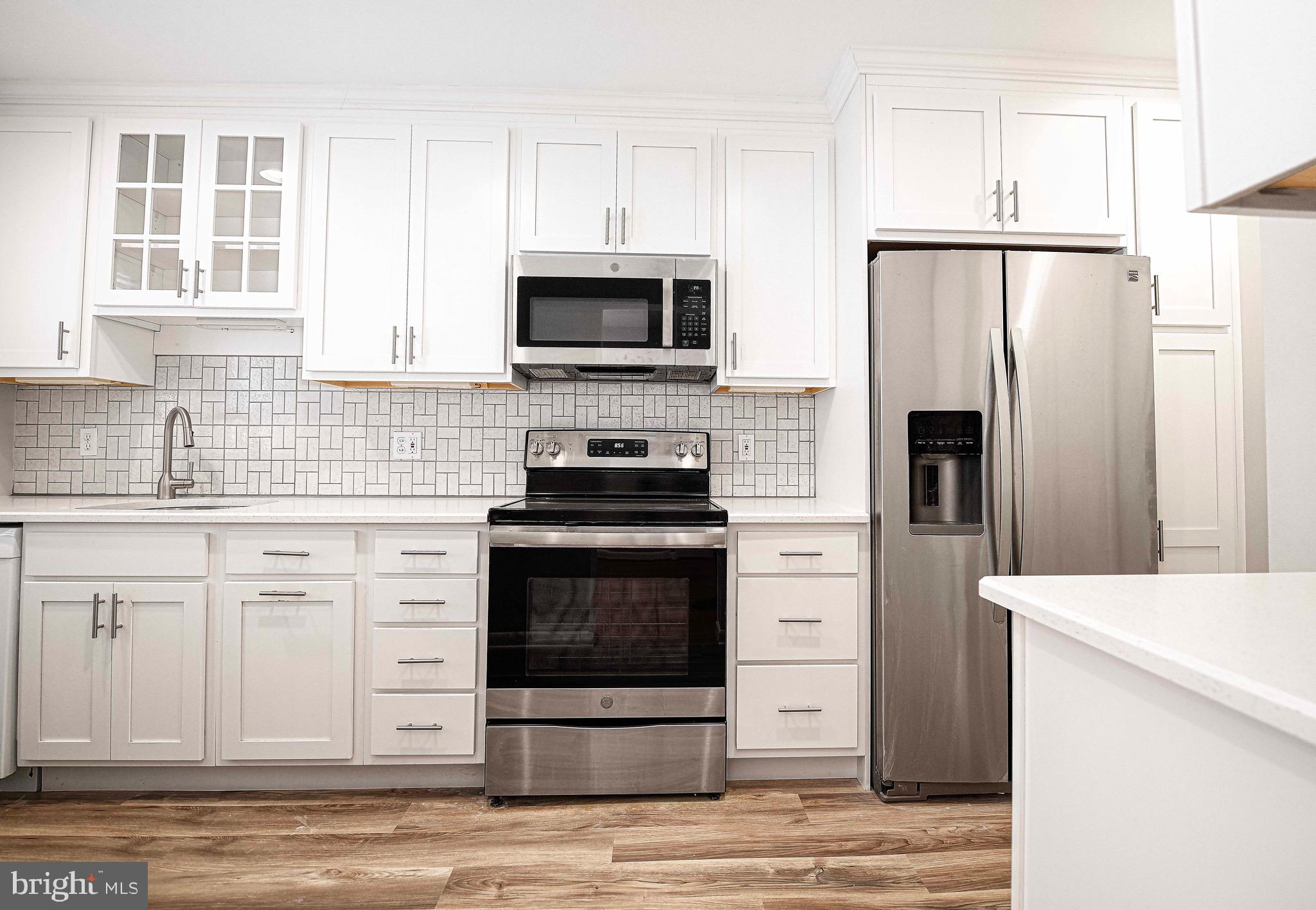 8559 Morven Road Baltimore, MD 21234 - Photo 10 of 27 a kitchen with white cabinets stainless steel appliances and sink