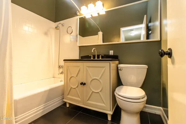 a bathroom with a granite countertop toilet sink and mirror