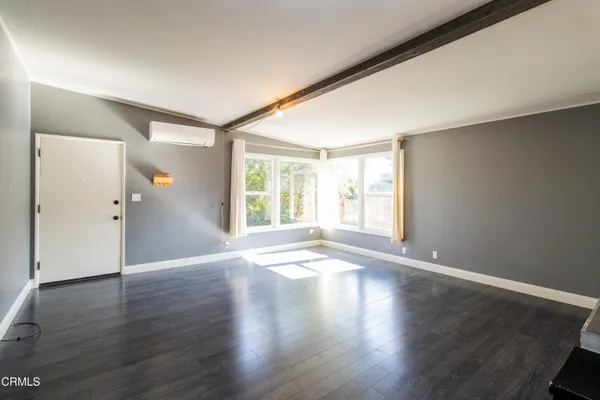 an empty room with wooden floor and a window