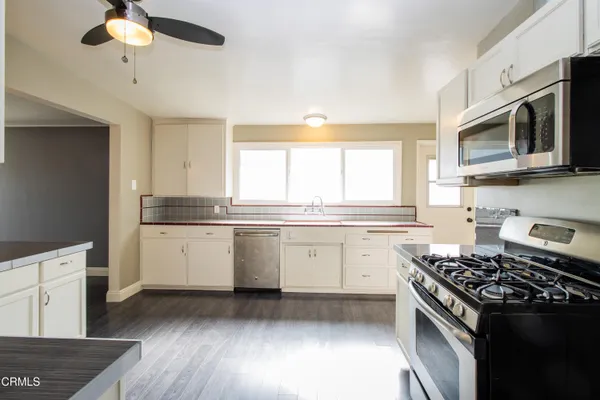 a kitchen with a stove a sink and a microwave