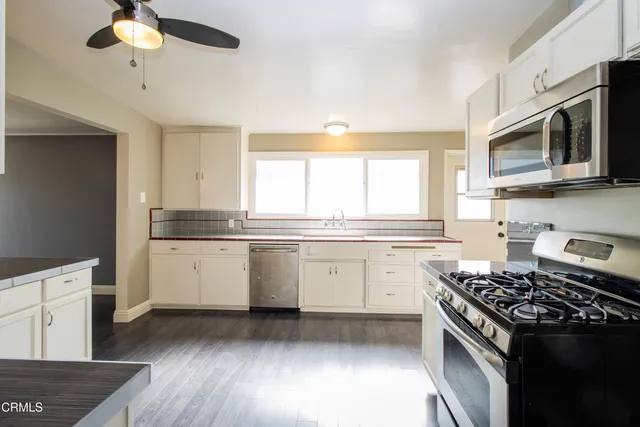 a kitchen with a stove a sink and a microwave
