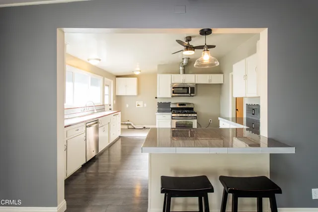 a kitchen with kitchen island a large counter top space appliances and cabinets