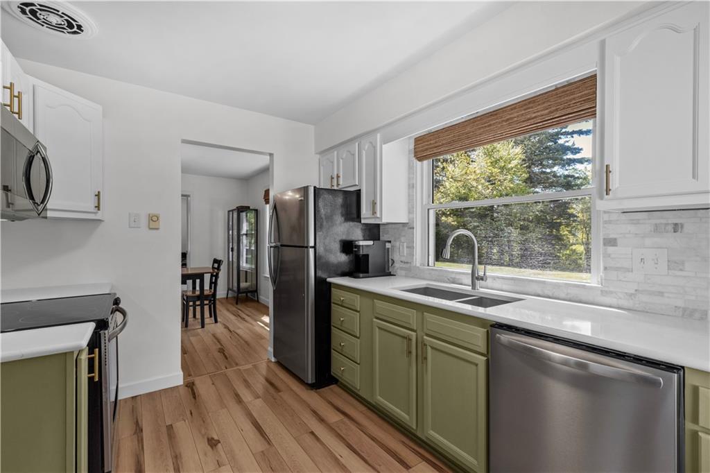 3566 Green Garden Road Aliquippa, PA 15001 - Photo 12 of 50 a kitchen with a sink a counter top space stainless steel appliances and a window
