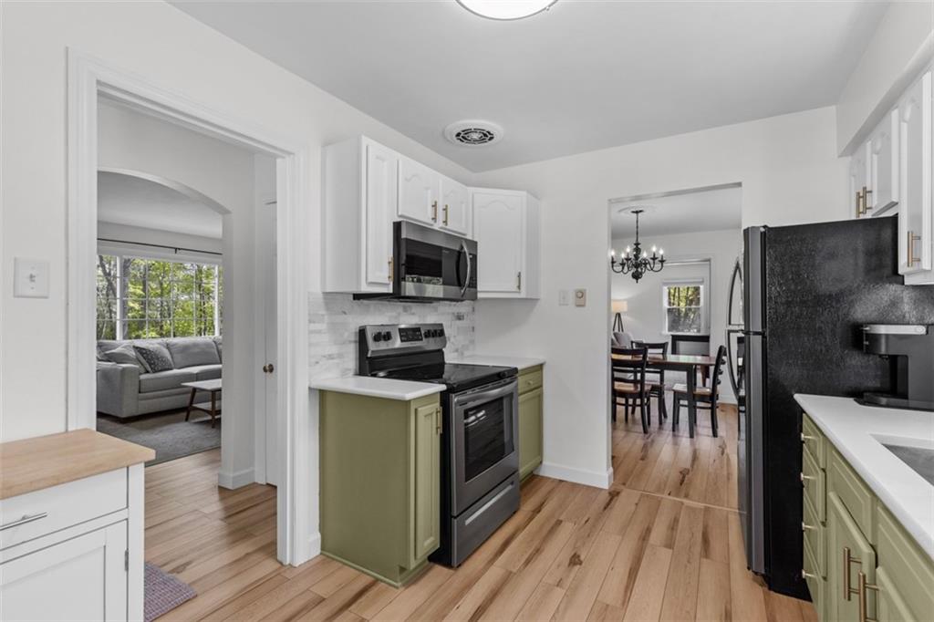 3566 Green Garden Road Aliquippa, PA 15001 - Photo 14 of 50 a kitchen with granite countertop a stove top oven a sink dishwasher a dining table and chairs with wooden floor