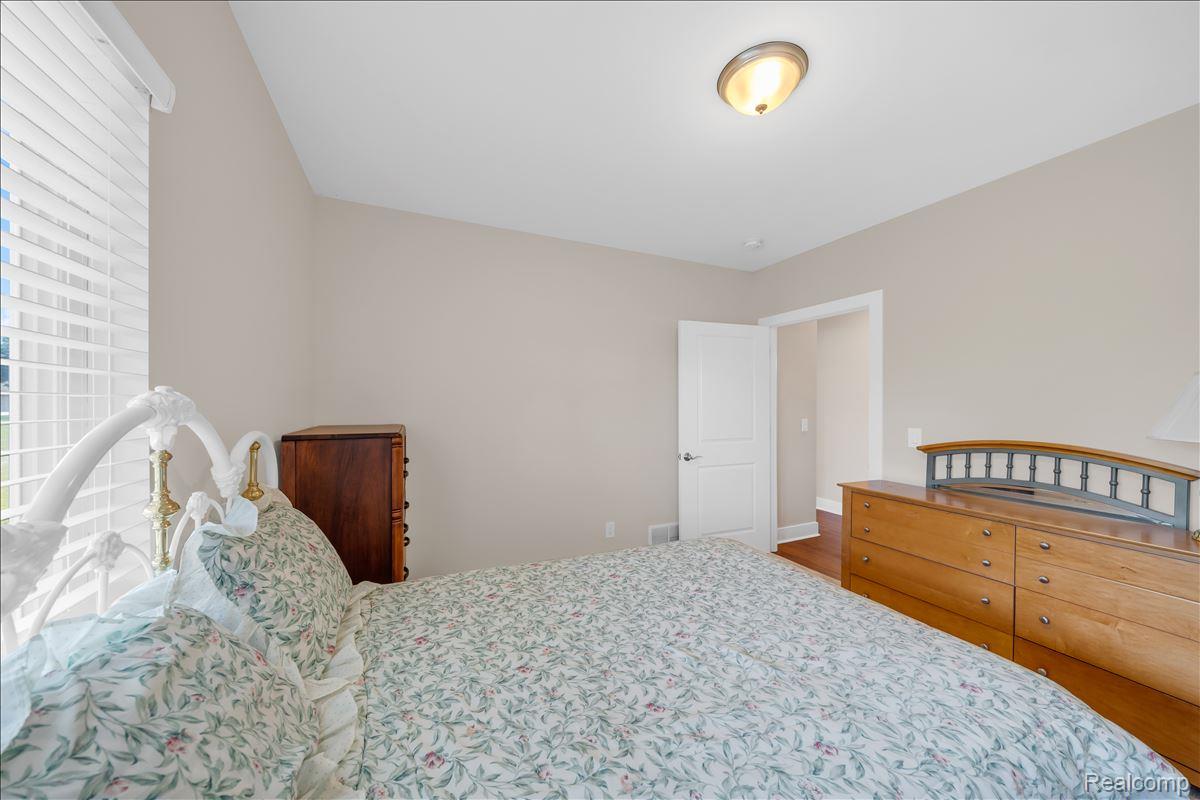 4266 McCandlish Road Grand Blanc, MI 48439 - Photo 48 of 68 Room with neutral-toned walls, wood-finish flooring, a white paneled door, and a flush-mount ceiling light fixture