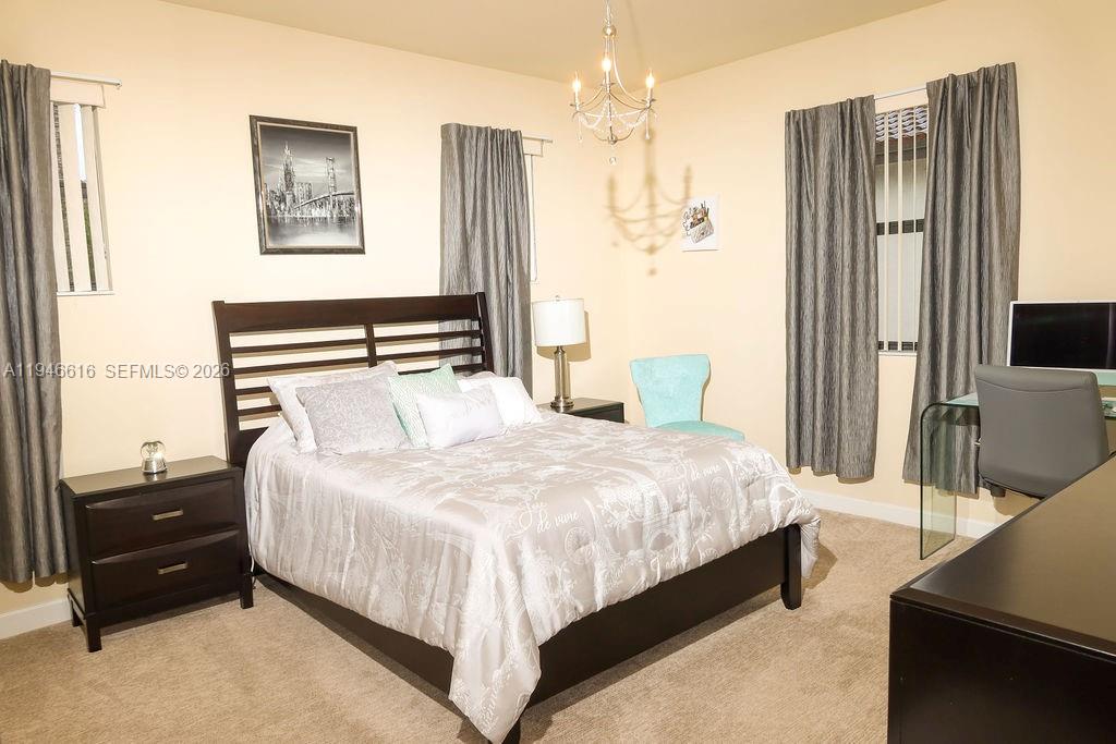 11601 Southwest 232nd Lane Homestead, FL 33032 - Photo 14 of 32 a bedroom with a bed and a flat tv screen on dresser