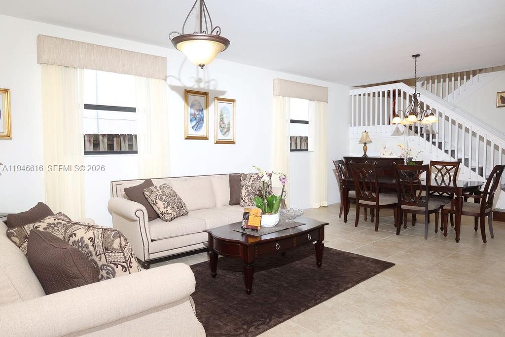 11601 Southwest 232nd Lane Homestead, FL 33032 - Photo 2 of 32 a living room with furniture a dining table and a window