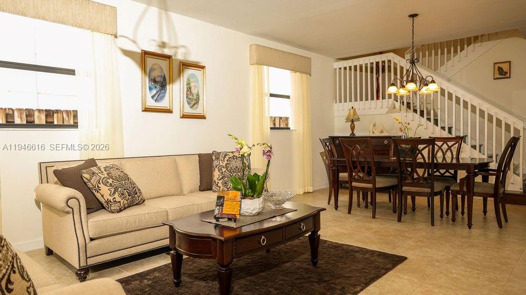 11601 Southwest 232nd Lane Homestead, FL 33032 - Photo 6 of 32 a living room with furniture a rug and a dining table