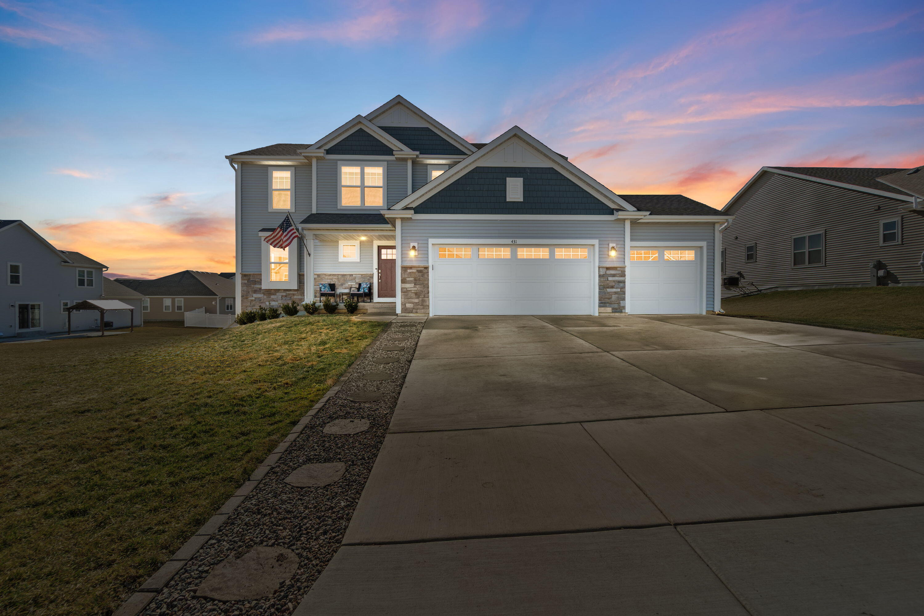 431 Nottingham Court Union Grove, WI 53182 - Photo 1 of 1 Stunning curb appeal at sunset with a 3-car garage, stone accents, and welcoming front entry.