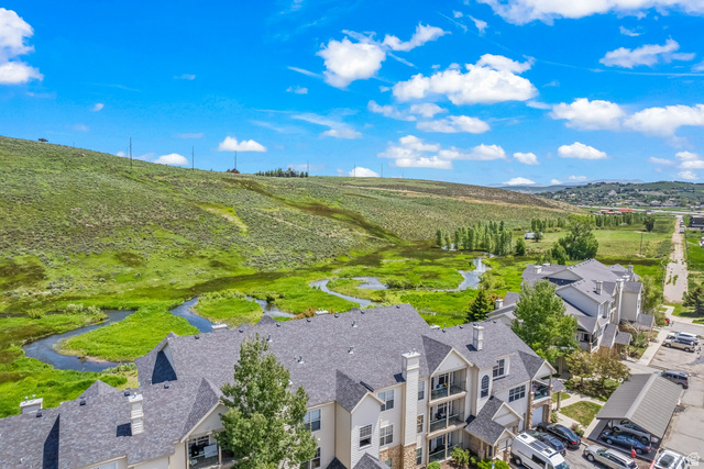 900 Bitner Road, Unit K25 Park City, UT 84098 - Photo 4 of 35 Multi-story residential buildings featuring gabled roofs and balconies overlooking a winding stream and natural green landscape