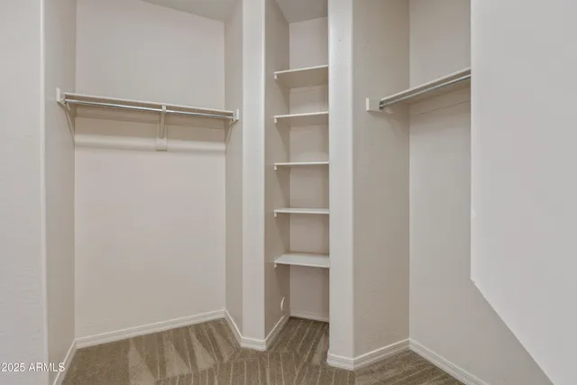 a view of walk in closet with empty racks