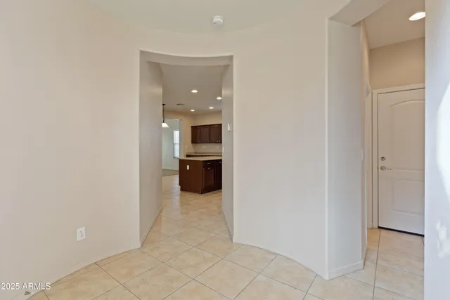 a view of a kitchen from the hallway with a livingroom and a kitchen space