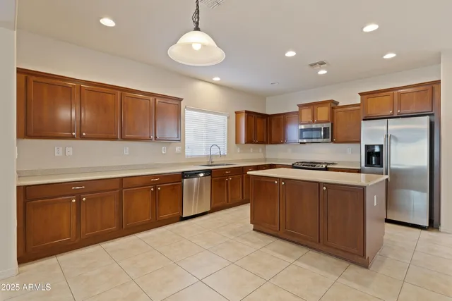 a kitchen with stainless steel appliances granite countertop a sink counter space cabinets and a refrigerator