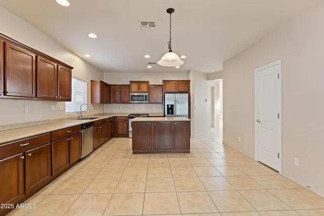 a large kitchen with stainless steel appliances granite countertop a stove and cabinets