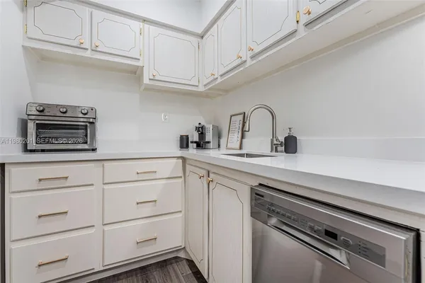 a kitchen with white cabinets stainless steel appliances and sink