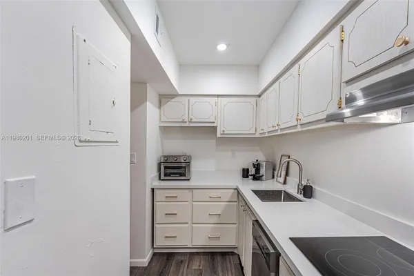 a kitchen with white cabinets and appliances