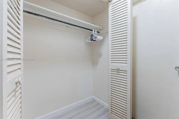 a view of a room with wooden floor and a shower