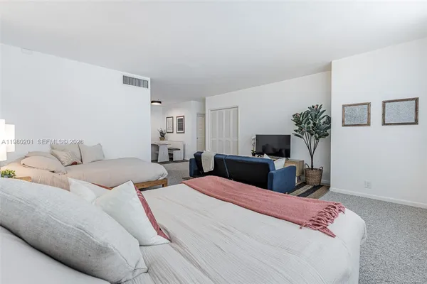 a bedroom with a bed and a potted plant