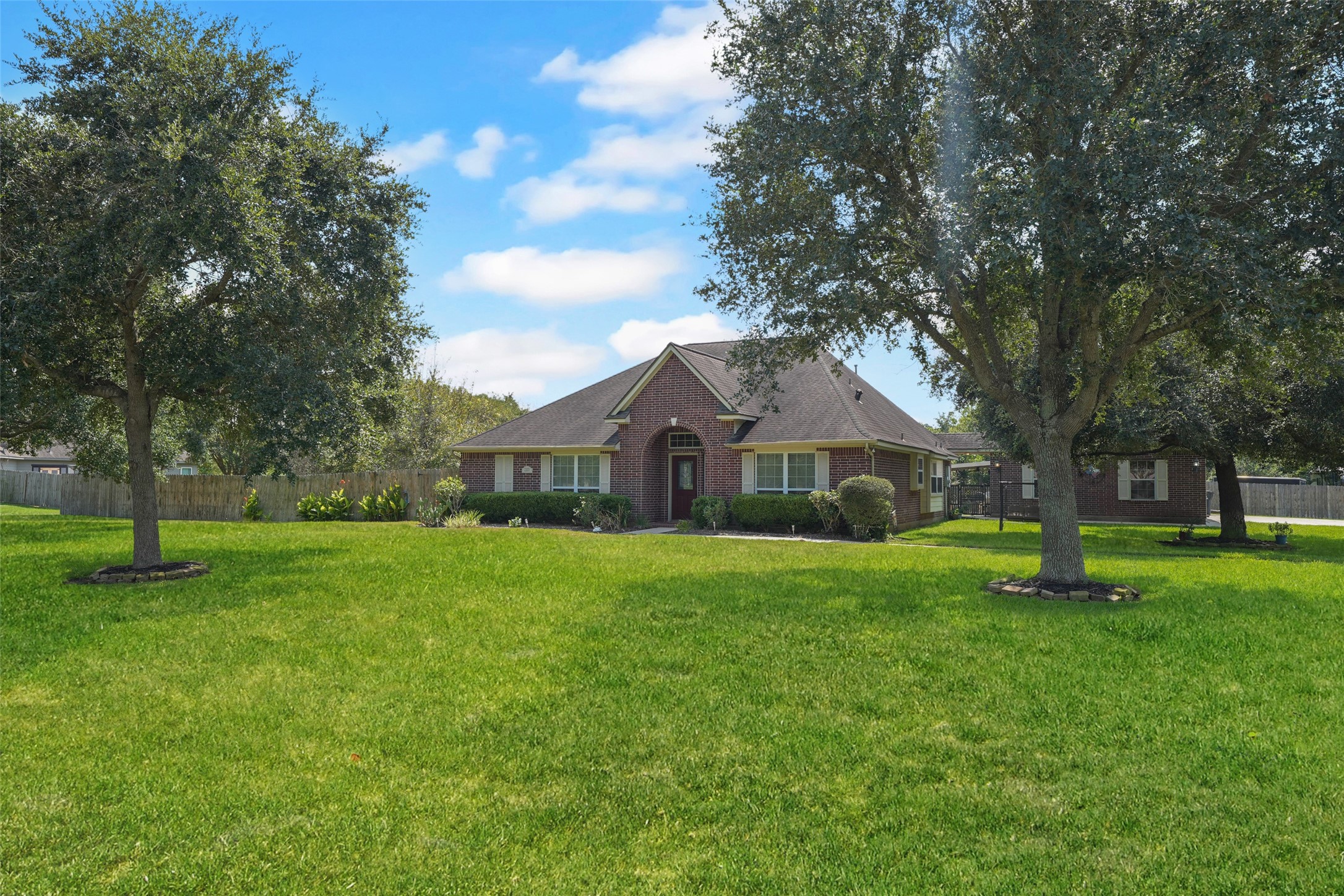 2203 Red Bird Lane Pattison, TX 77423 - Photo 1 of 46 This photo features a charming brick home with a manicured front lawn, mature trees, and a spacious yard. The house has a classic design with a pitched roof and large windows, providing ample natural light. Perfect for buyers seeking a serene and welcoming property.