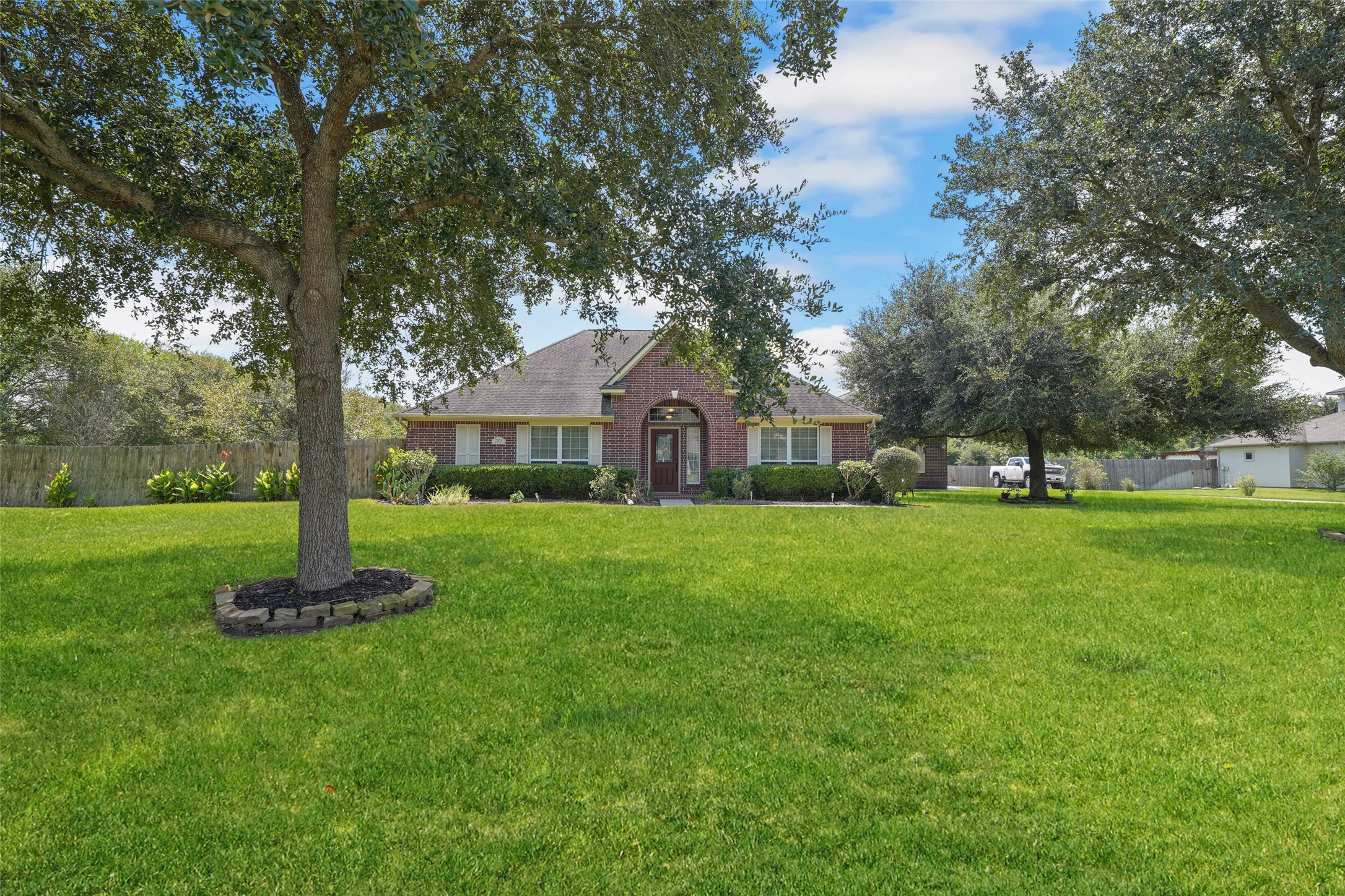 2203 Red Bird Lane Pattison, TX 77423 - Photo 2 of 46 This charming brick home features a spacious, well-maintained front yard with mature trees, providing ample shade and a welcoming atmosphere.