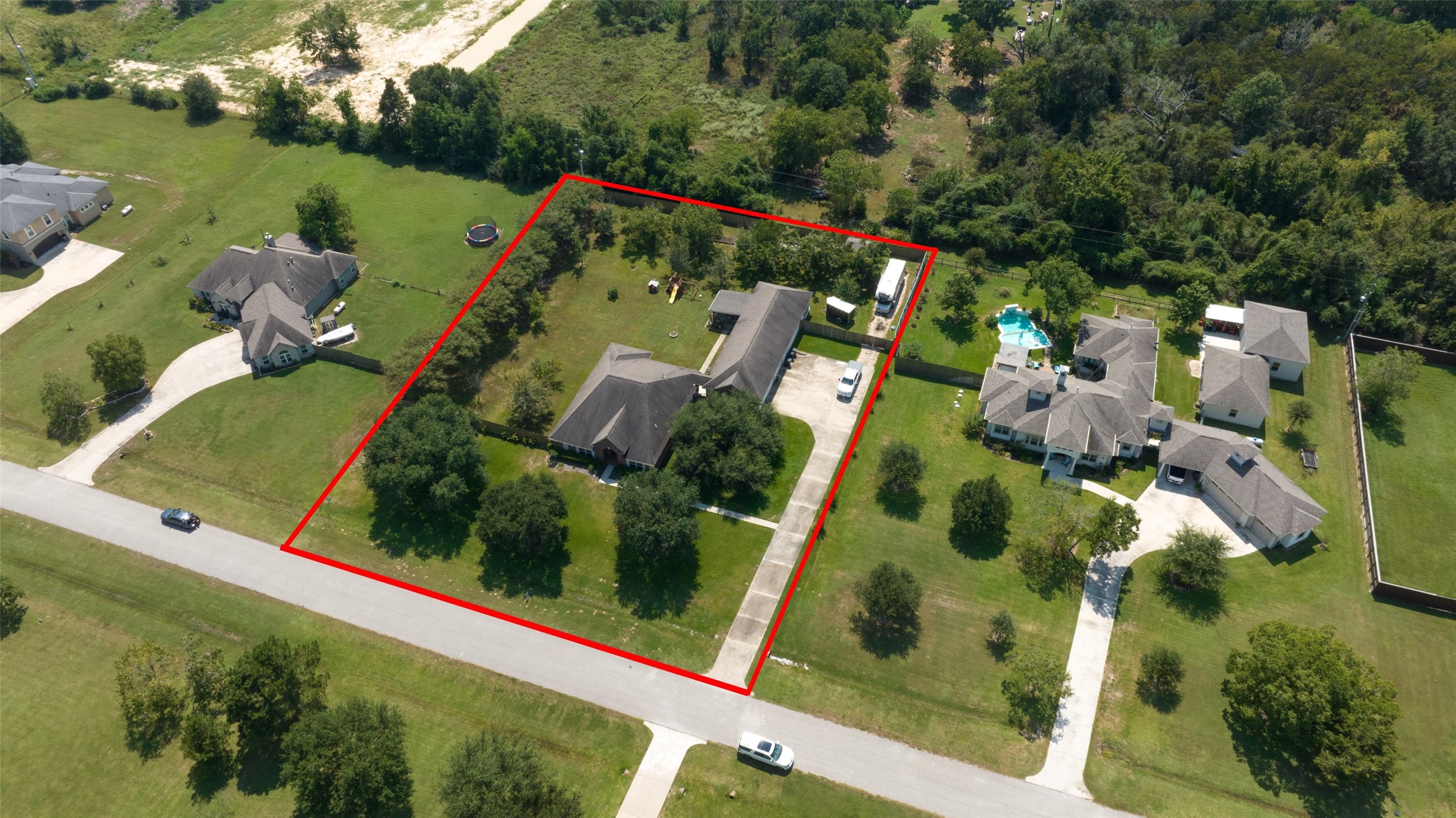2203 Red Bird Lane Pattison, TX 77423 - Photo 4 of 46 This aerial photo shows a spacious property outlined in red, featuring a central house with a long driveway and ample greenery. It's situated in a neighborhood with other large homes, offering a sense of privacy and plenty of outdoor space.