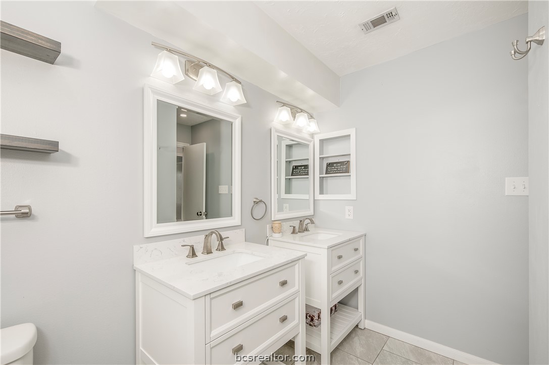 2009 Cobblestone Lane Bryan, TX 77807 - Photo 18 of 23 a bathroom with a sink a toilet and a mirror