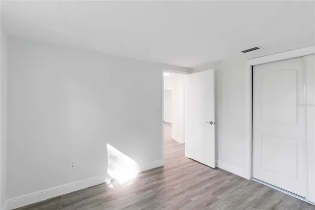 a view of an empty room with wooden floor