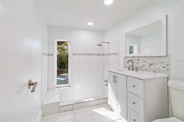 a spacious bathroom with a double vanity sink a mirror and a bathtub