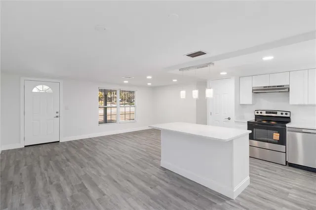 a large kitchen with stainless steel appliances granite countertop a stove a sink and a refrigerator