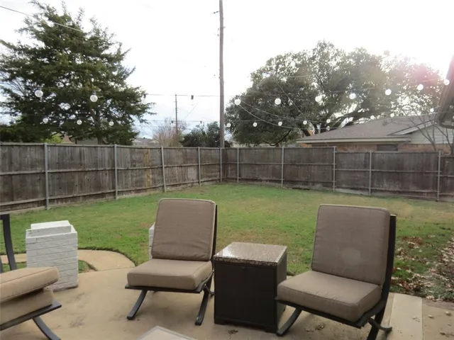 a view of a backyard with couches chairs and a yard