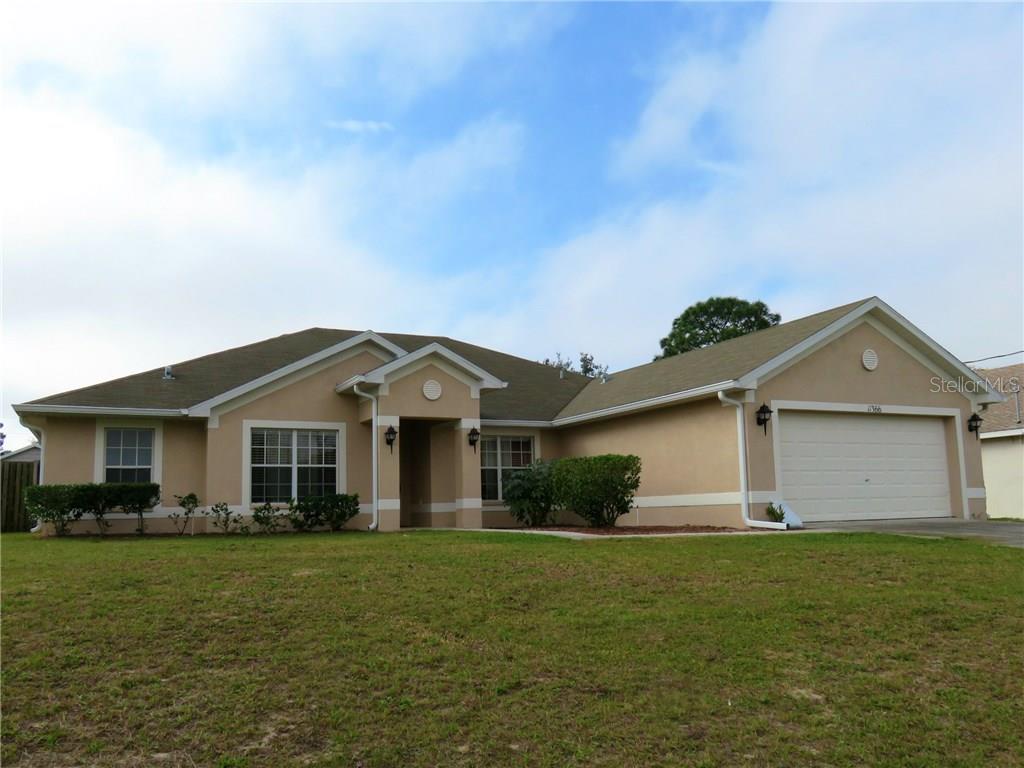 11366 Riddle Drive Spring Hill, FL 34609 - Photo 1 of 1 a front view of a house with a garden