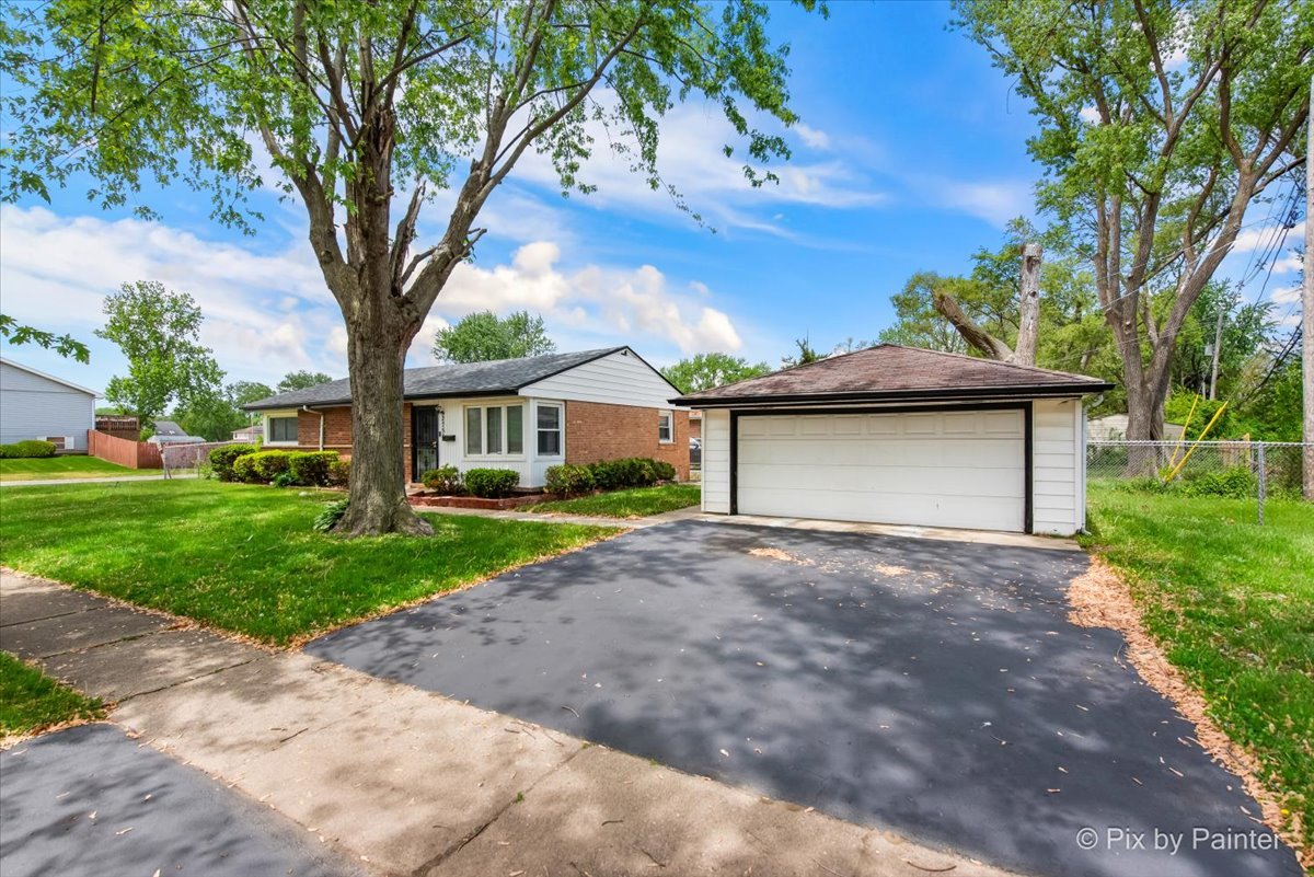 2756 Lancaster Drive Markham, IL 60428 - Photo 3 of 6 a front view of a house with a garden and trees