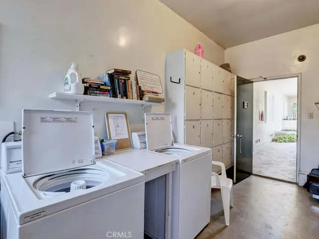 a room with a sink a bed and a refrigerator