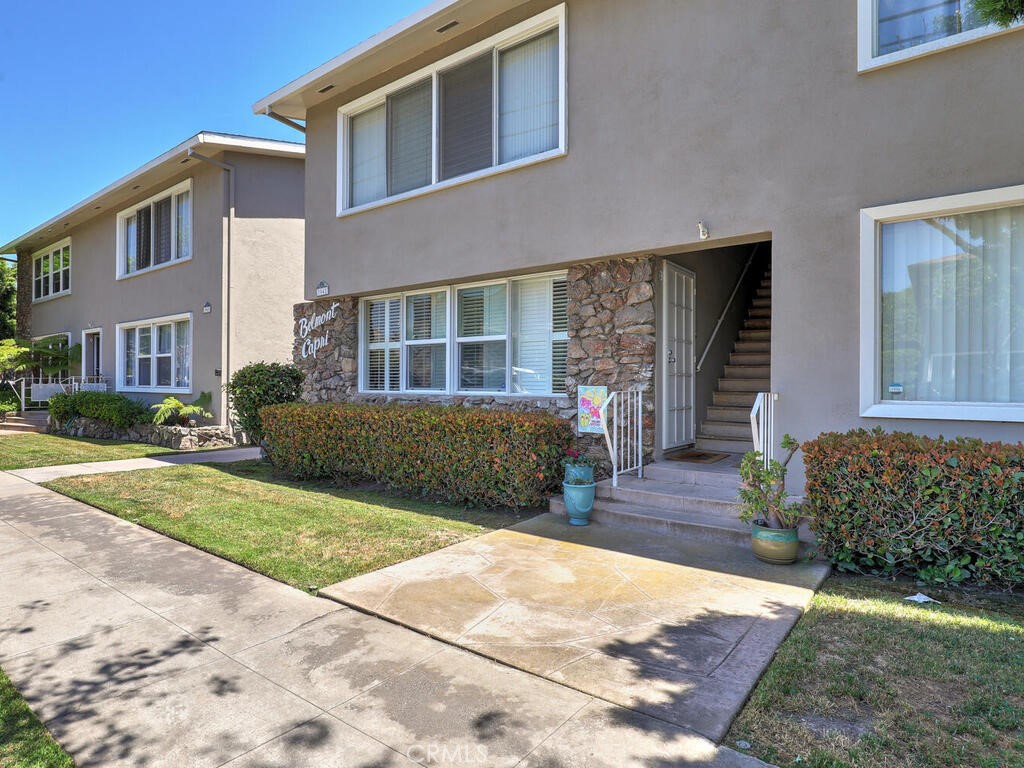 3042 East 3rd Street, Unit 5 Long Beach, CA 90814 - Photo 4 of 25 a view of a brick house with many windows plants and large tree