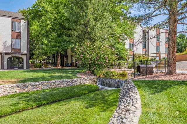 a view of a fountain in front of a house with a big yard