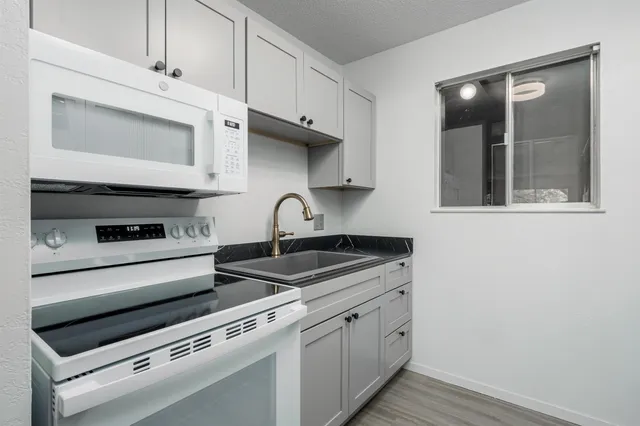 a kitchen with stainless steel appliances granite countertop a sink and a stove