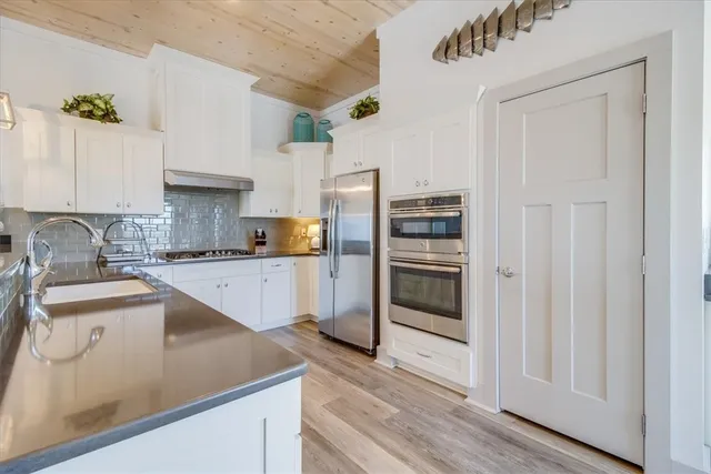 a kitchen with granite countertop a refrigerator and a sink