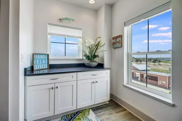 a kitchen with white cabinets and a window