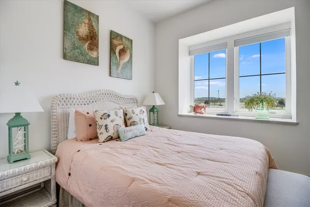 a bedroom with a bed and a large window