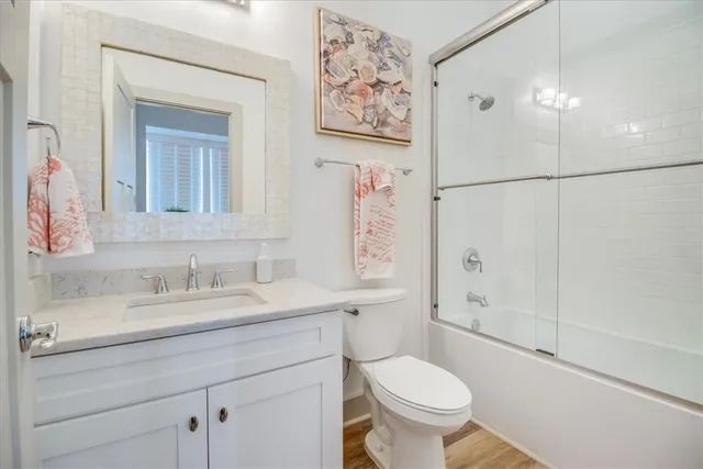 a bathroom with a granite countertop toilet sink and a mirror