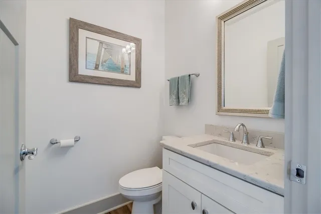 a bathroom with a granite countertop toilet sink and mirror