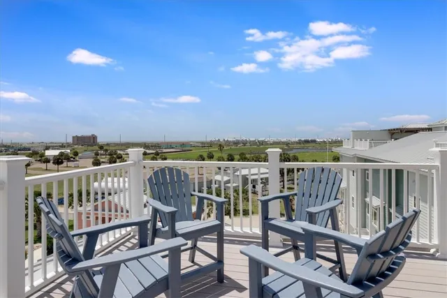 a view of a balcony with wooden chairs